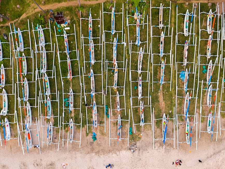 Aerial view of traditional fishing boats lined up on a beach in Bali