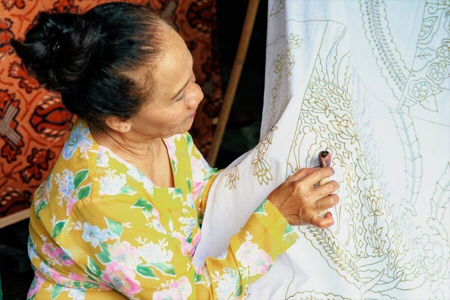 An Indonesian woman crafting batik patterns by hand