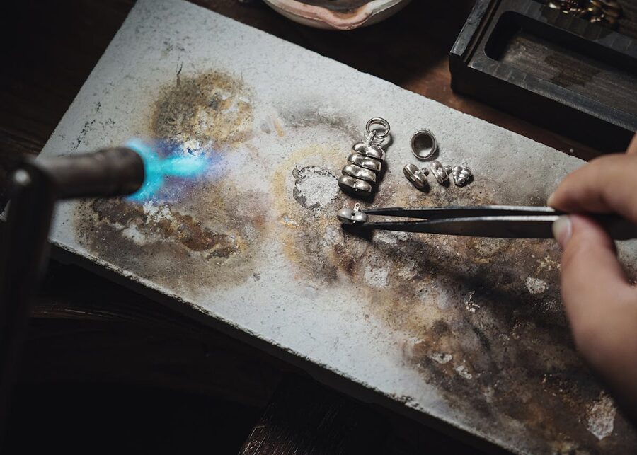 Jeweller using a blowtorch to solder silver