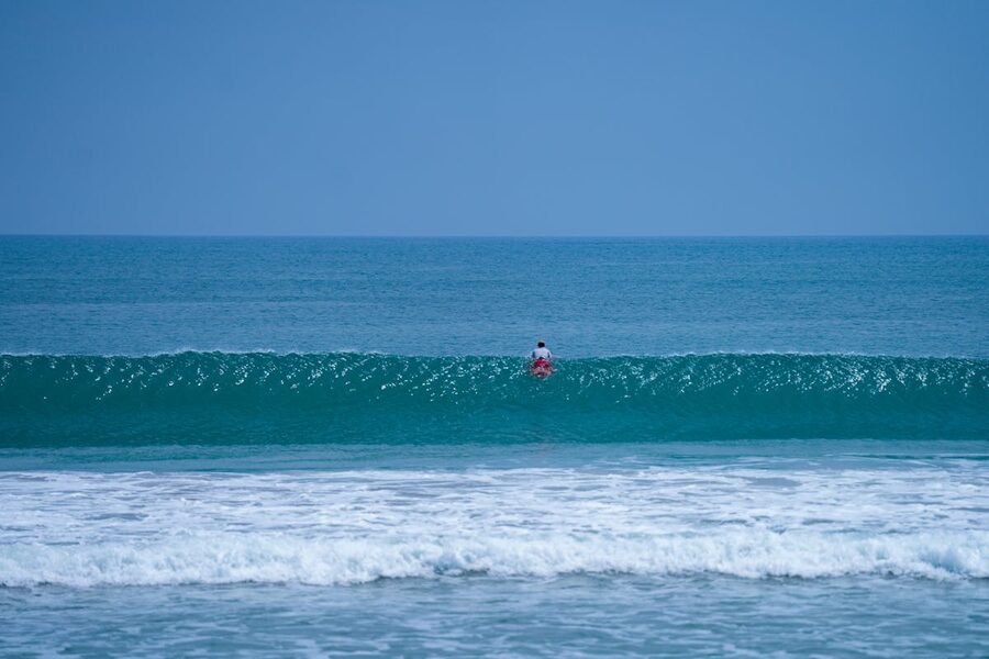Surfer paddling out at Kuta Beach Bali