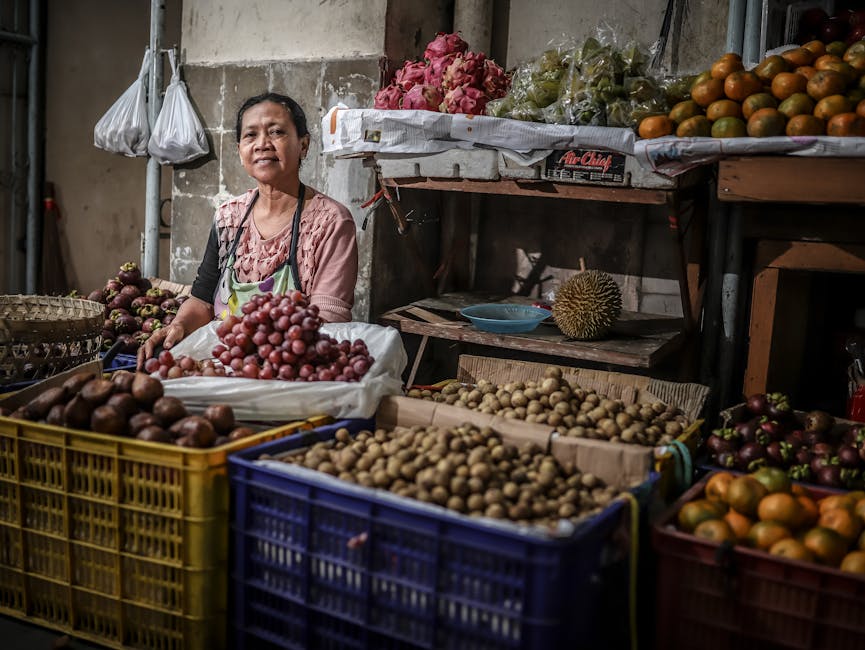 Indonesian fruit vendor with mangosteens, salaks, and tropical fruit at a traditional market