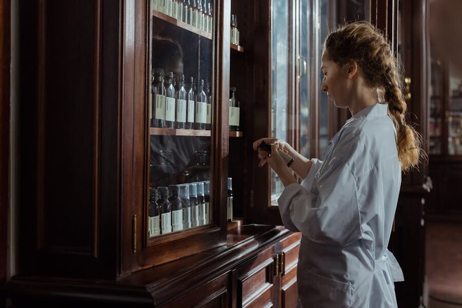 Pharmacist arranging medicine bottles in a pharmacy cabinet