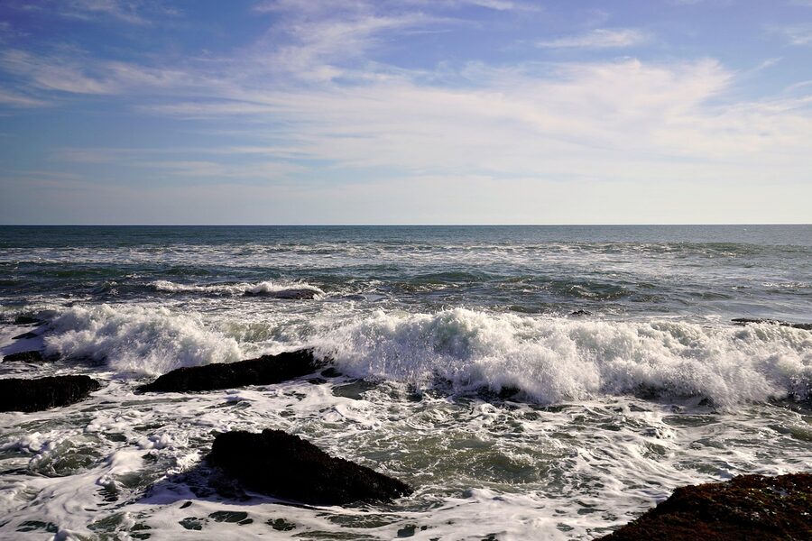 The natural arch beside Tanah Lot temple with breaking waves below