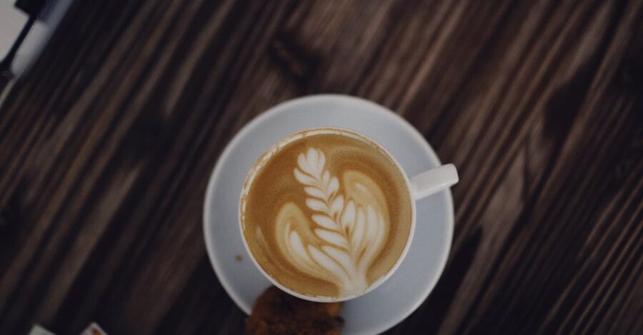 A cappuccino with latte art in a white cup at an Ubud specialty coffee bar