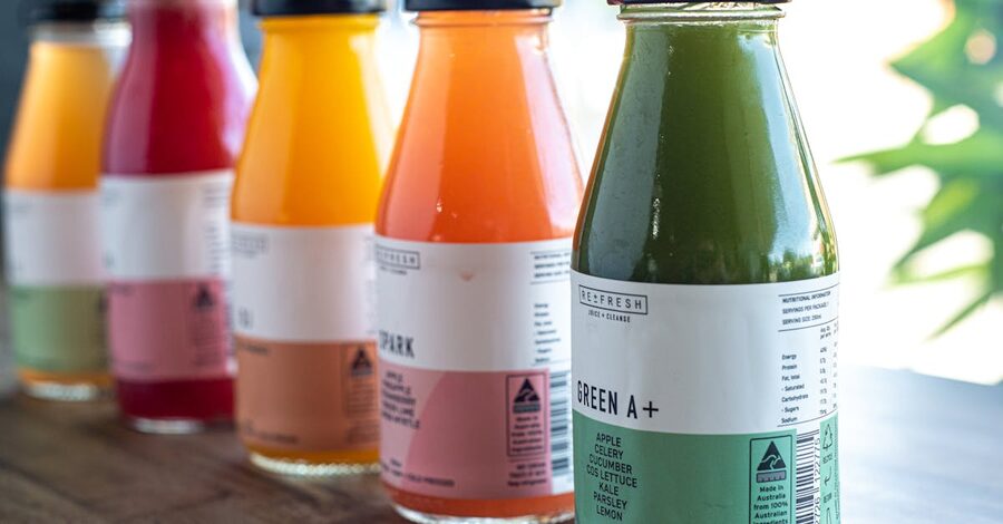 A row of cold-press juices in glass bottles at an Ubud cafe