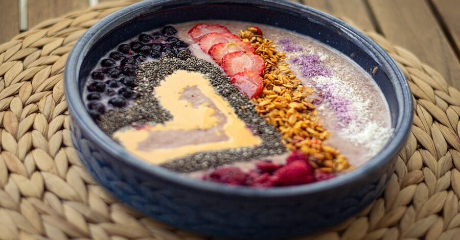 A vibrant smoothie bowl topped with fresh fruit and seeds at an Ubud cafe