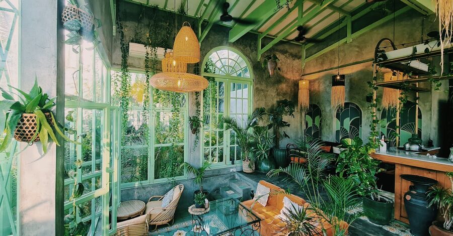 A vintage cafe interior in Ubud with greenery and patterned tile floor