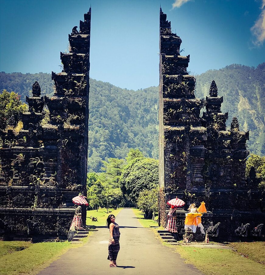Handara Gate Bali entrance with mountains and a lone visitor walking through