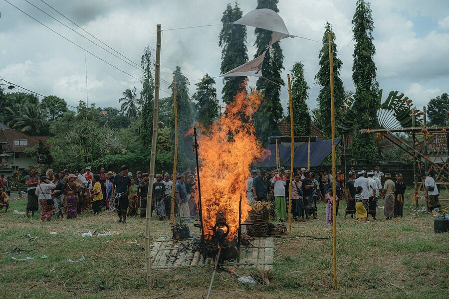 Burning ngaben pyre with cremation tower elements in a Bali village setra