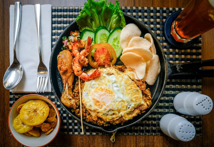 Plate of nasi goreng with prawn satay fried egg and prawn crackers at a Bali warung
