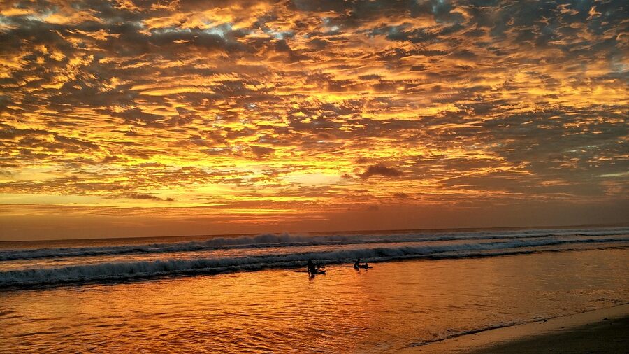 Sunset waves at Kuta Beach with two surfers in the line-up