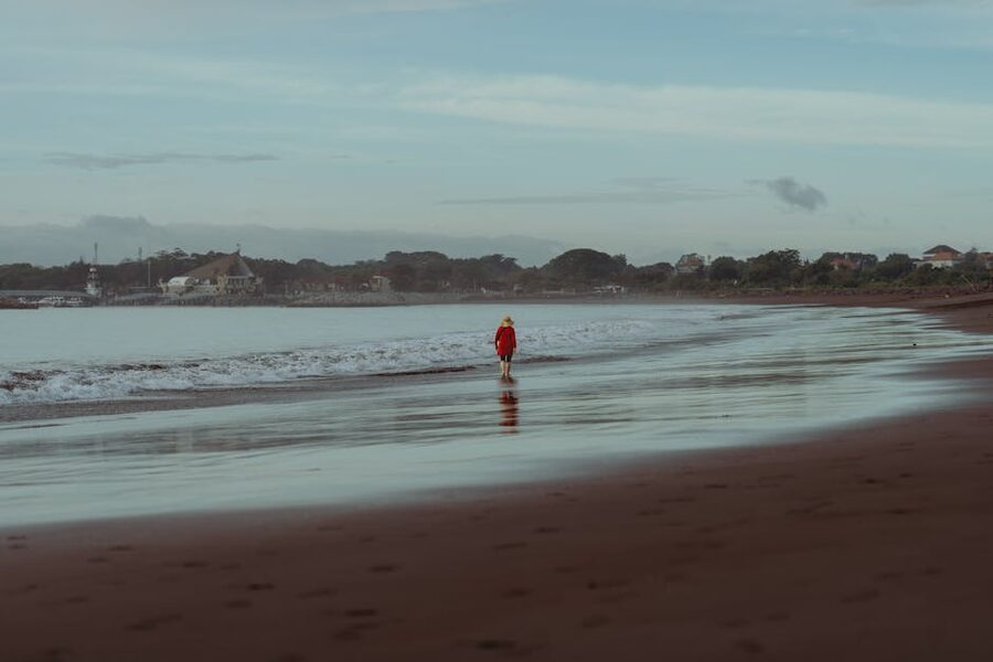 A solo walker on Sanur Beach shoreline