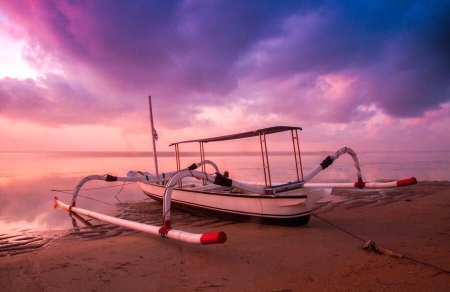 Traditional outrigger boat on Sanur beach at sunrise