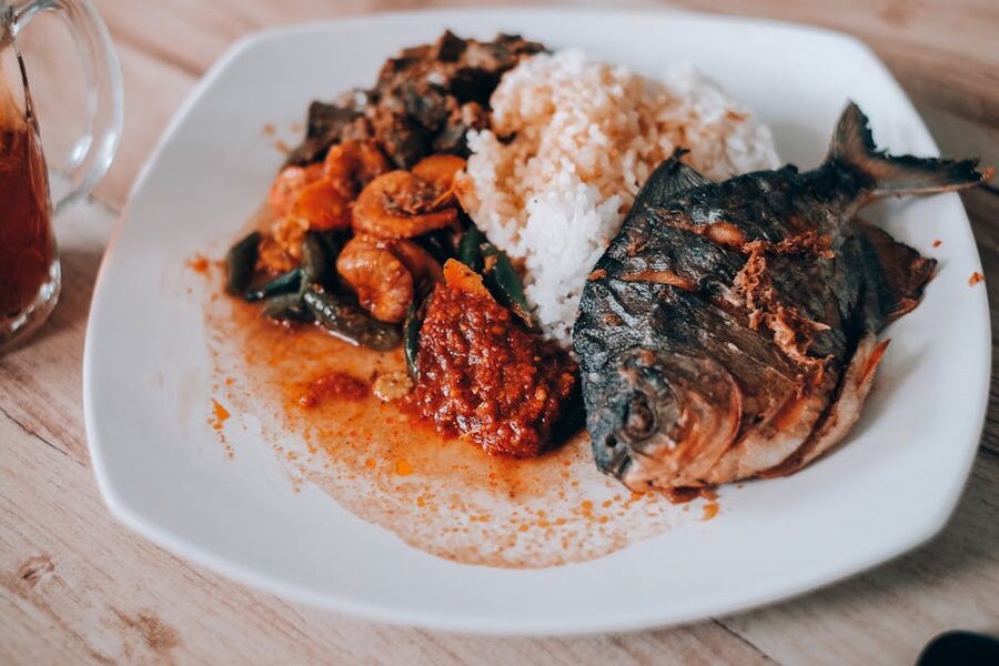 Whole fried fish served with rice and red sambal at an Indonesian warung
