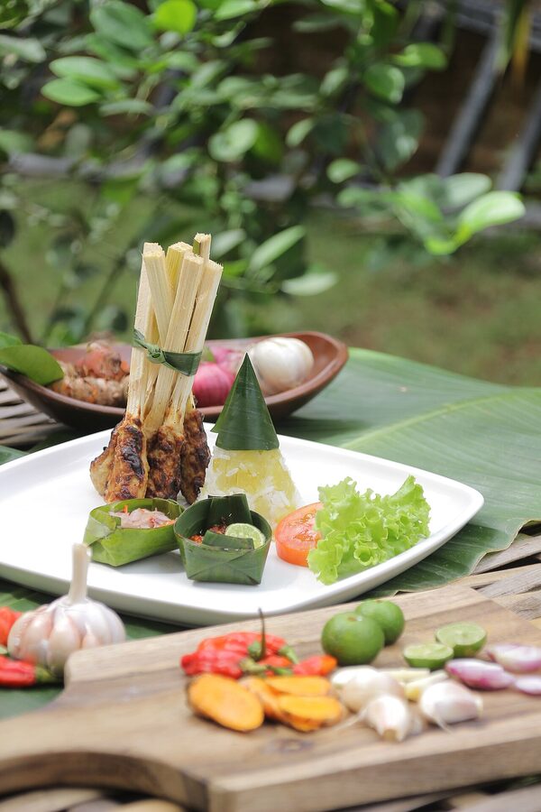 Bali sate lilit on lemongrass sticks served with rice and chilli garnishes