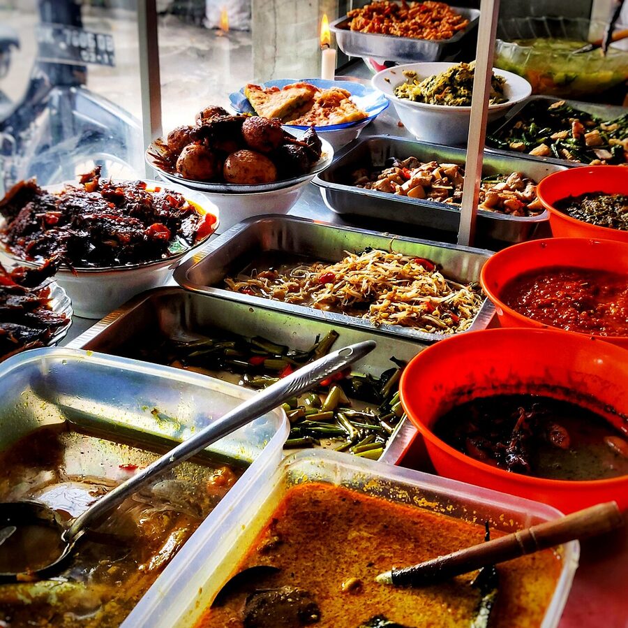 A spread of Indonesian dishes on a warung counter ready for lunch
