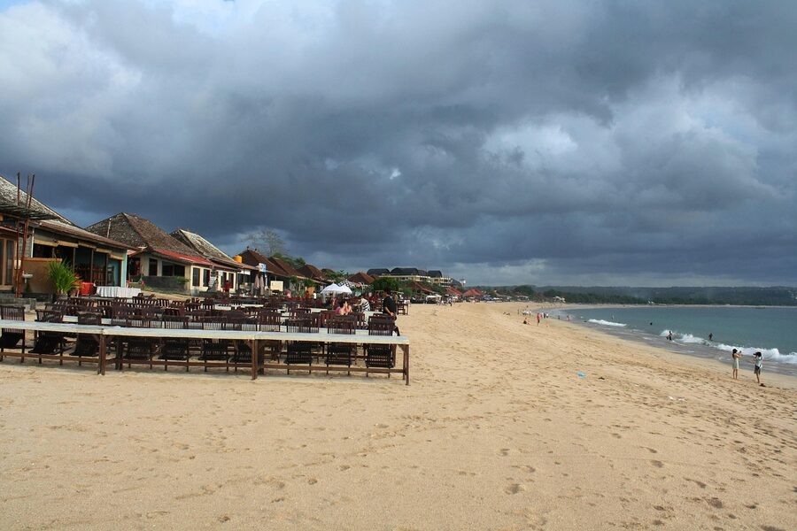 The wide flat beach at Jimbaran Bali with grills and tables along the sand