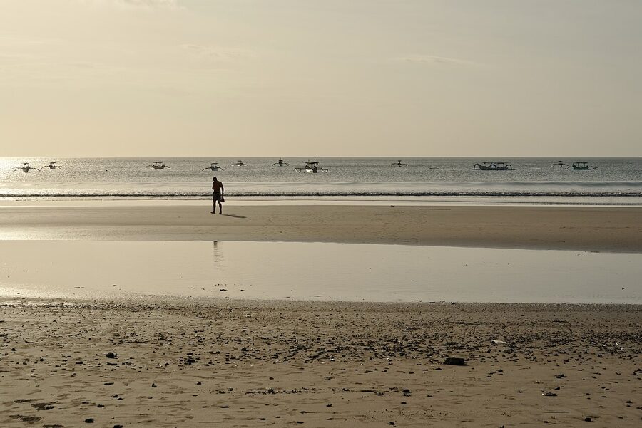 Kuta Beach Bali in the morning with traditional jukung outrigger boats anchored offshore