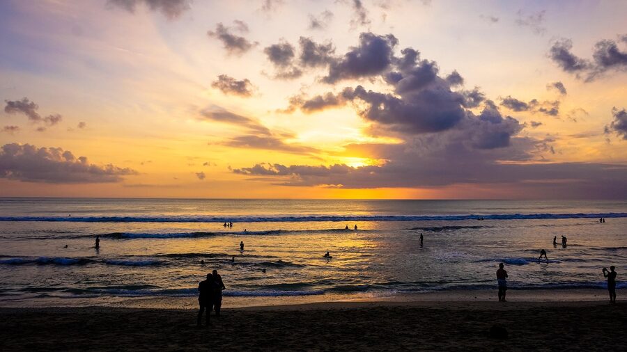 Seminyak beach umbrellas and beanbags at sunset Bali
