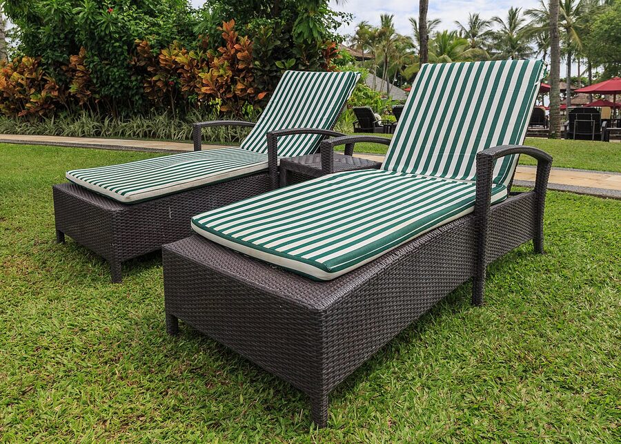 Two sunbeds with green-and-white striped cushions on a manicured Nusa Dua resort lawn