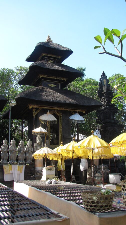 Pura Silayukti temple gateway with ceremony decorations and yellow umbrellas in Padangbai