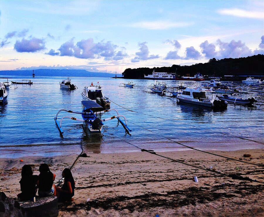 Sunset over Padang Bai harbour with moored jukung outrigger boats