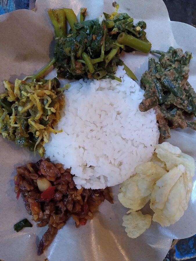 Nasi campur platter at a Bali warung with vegetables, rice, and sambal