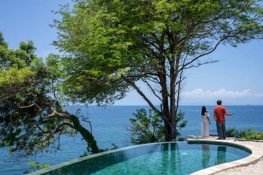 Couple at infinity pool overlooking Bali coastline